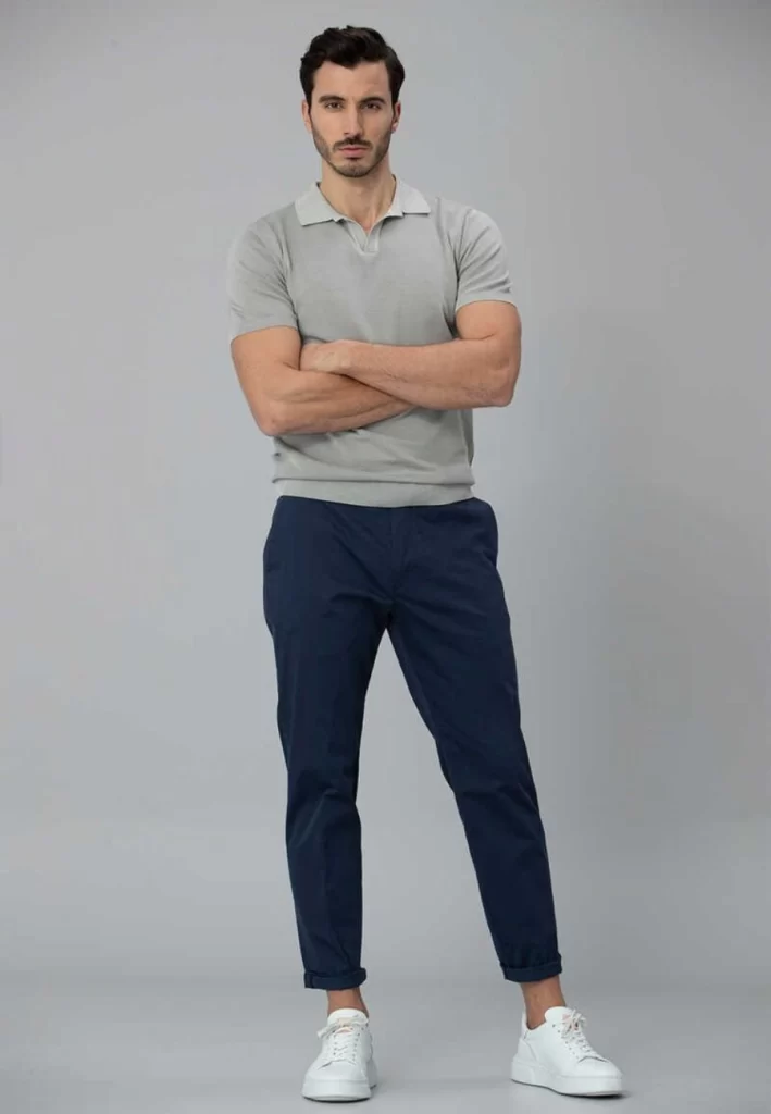 Man wearing grey polo and navy trousers