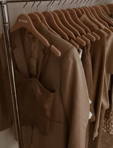 Brown outfits hanging neatly on rack